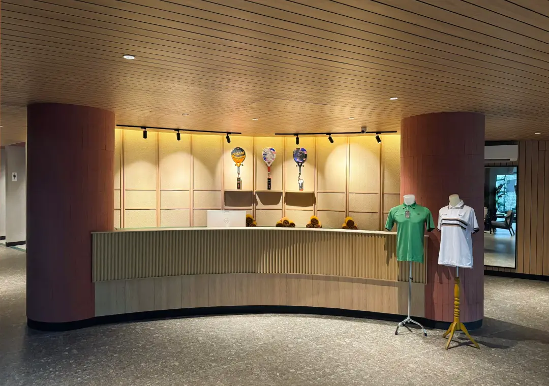 Curved reception desk with rackets displayed